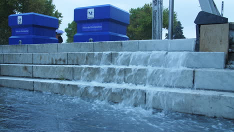 Agua-Que-Fluye-Pesadamente-En-Las-Escaleras-En-La-Plaza-De-La-Comedia-De-Montpellier-Francia,-Clima-Húmedo